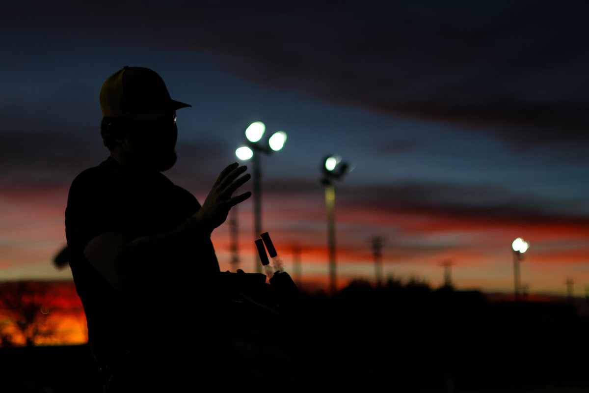 Trap shooter at dusk with range lights